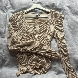 Draperad tröja från Other Stories  - Knappt använd, storlek 38 men upplevs något mindre fast med stretch. Framhäver kroppen snyggt! Beige/benvit färg. 