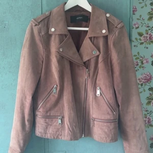 Jacka - Rosa jacka. Använd väl. Har ändrat färg på vissa ställen då det förekommer mörka fläckar därav billigt pris. Kan skicka fler bilder privat. Äkta mocka. Storlek L men passar mig som har M.