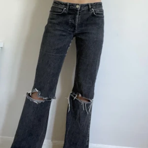 Jeans med hål - Mörkgråa jeans med stora hål på knäna Långa, går ner till marken på mig som är 175 Storleken är S men skulle säga att de passar M också