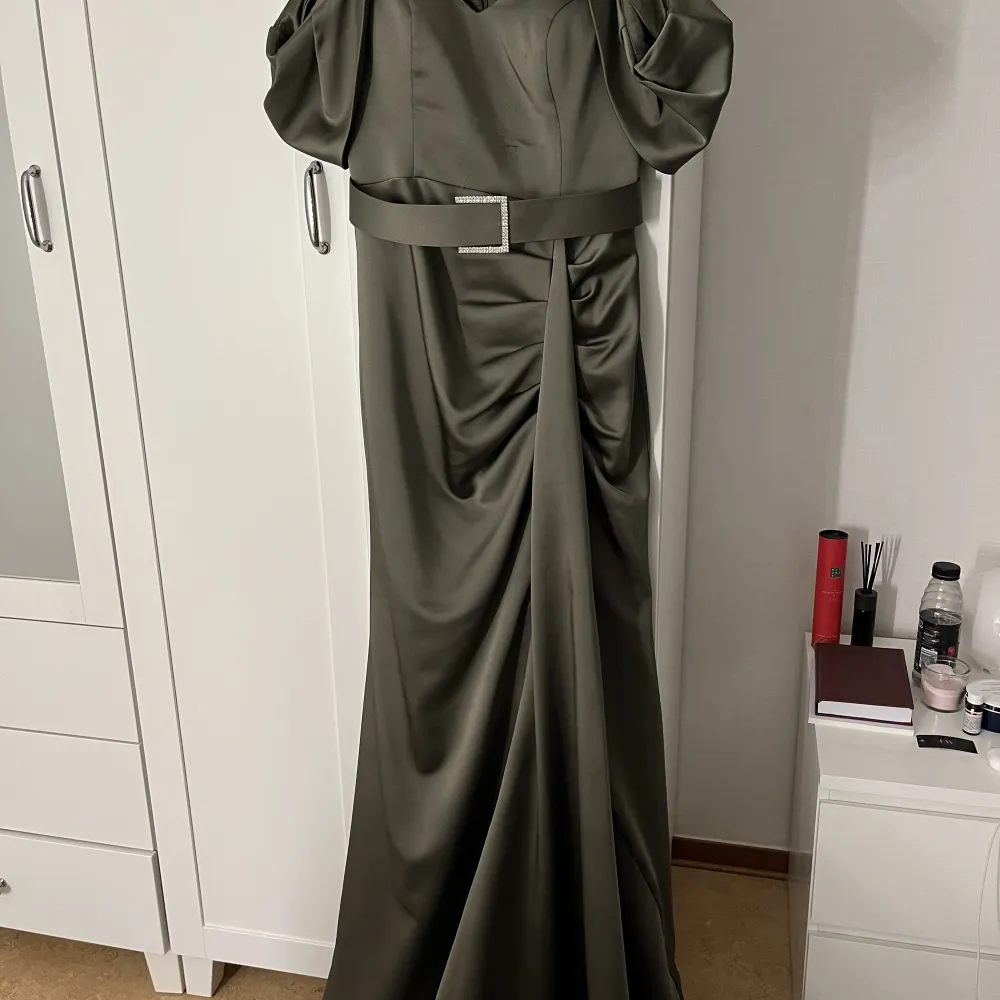 Olivgrön klänning med släp  Silver diamant bälte Passar S/M  Använd endast en gång  Kan hämtas upp i Örebro  . Klänningar.