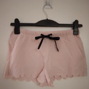 Gammelrosa / rosa shorts med laserskurna kanter och fickor. Strlk: 34-36 / XS-SMALL. Felfria. - Gammelrosa / rosa tunna shorts med laserskurna kanter och fickor, knytband I midjan. Strlk: 34-36 / XS-SMALL. Material: Polyester. Felfria.