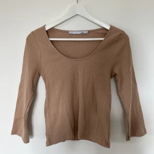 Beige ribbadtröja - Ribbad beige/brun tröja från Lager 157. Halvlånga ärmar. Aldrig använd. 95% cotton / 5% elastane Storlek M / L ✨✨✨