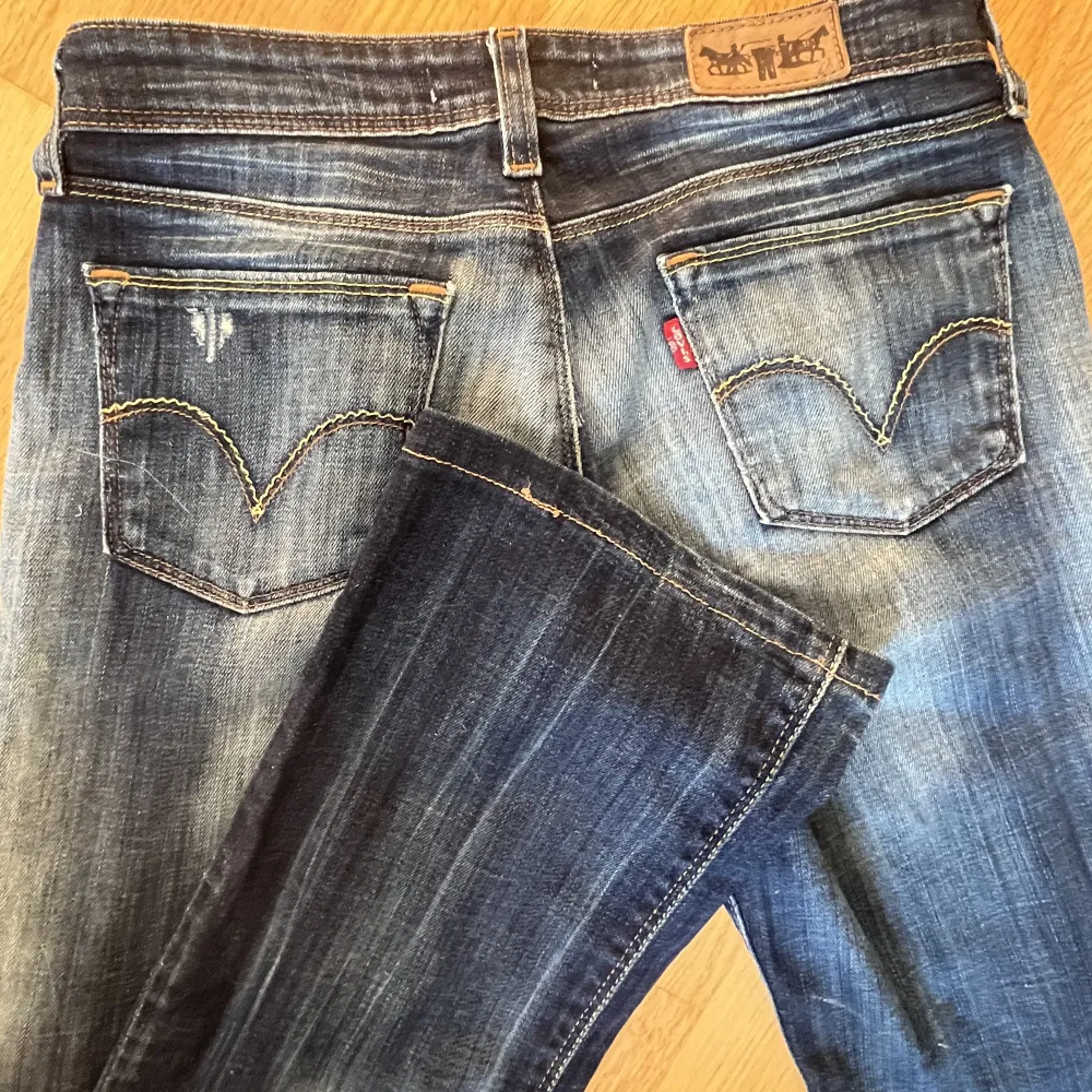 Ett par låga bootcut jeans från Levis. Midjemått tvärs över 35 cm. Innerbenslängd 77 cm. Passar perfekt på mig med storlek S. Modell 572 bootcut. Verkligen en av mina favoriter men säljer på grund av att jag har flera liknande par!❤️. Jeans & Byxor.
