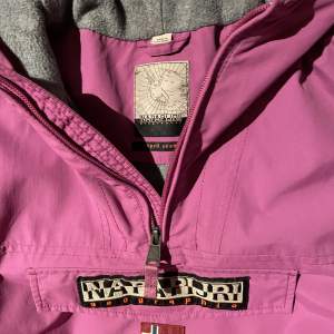 Det är en halv Zip jacka från Napapijri i färgen lila. Den är perfekt till att åka skidor i eller ha till vardags. Skicket är 9/10
