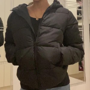 Svart Jacka  - En varm vinterjacka med fickor och en luva. Den är helt ny. Originalpris 600 kr 