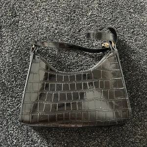 svart väska - skit snygg svart väska med gulddetaljer! jag älskar den!