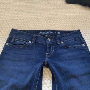 Säljer ett par lågmidjade utsvängda jeans från Guess i bra skick❤️ Midjemått=79cm Innerbenslängd=84cm Frakt står du för själv!💕