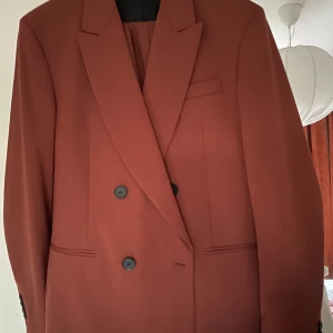 Roströd kostym Zara - Roströd kostym från Zara. Inköpt 2022 men aldrig använd. Byxor och kavaj är i storlek 50. 