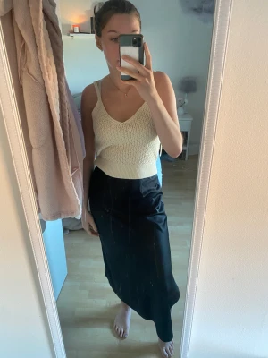 Svart satinkjol - Svart satinkjol från bikbok. Slits på höger sida. Går att bära både högt och lågt 