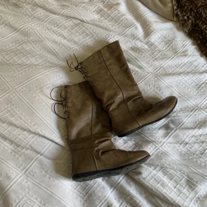 Vinterstövlar  - Boots i konstgjort läder, fodrade med snörning i bak. De är använda och har spruckit i fram se sista bilden. 🤎🤎