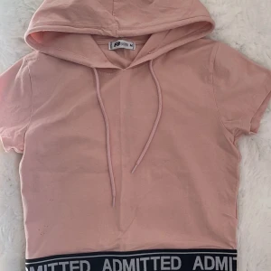 Tshirt  - En rosa tshirt med en luva i storlek M men sitter som ett S