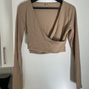 Croppad topp - Beige croppad topp från nelly i storlek M från 