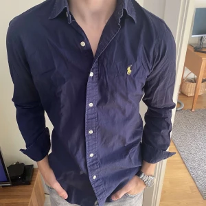 Ralph Lauren skjorta - Säljer nu denna snygga skjorta från polo Ralph Lauren. Perfekt nu till sommaren. Skjortan är i toppen skick och har inga defekter. Storleken är S. Han på bilden är 180. Dma för mer frågor!