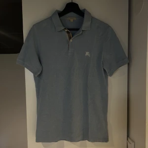 Burberry piké  - Burberry piké i storlek S. Superfint skick och helt felfri. Sjukt snygg ljusblå färg och perfekt nu till sommaren ☀️ Vid andra frågor eller funderingar är det bara att höra av sig!  Mvh! 