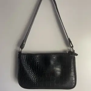En fin svart väska från Kappahl i ormskinn mönster. Använt ca 2-3 gånger och är i bra skick!