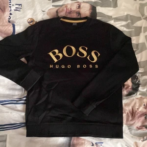 Guld Hugo Boss Sweatshirt  - Äkta Hugo Boss sweatshirt. Lappen inuti är avklippt men den är äkta man märker på materialet. Köpt för 1599. Pris kan diskuteras…