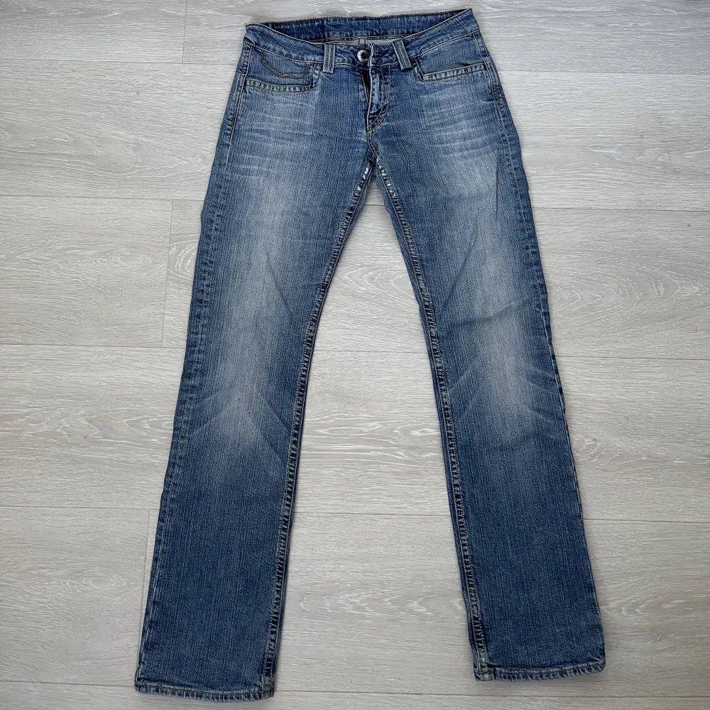 Säljer dessa snygga ljusblåa bootcut jeans då de är tyvärr för stora för mig som har storlek W27-28. Dessa är lågmidjade och har midjemåttet ca 86cm. Innerbenslängden är 82cm och 21cm (tvärs över, 42cm totalt) i the flare. Skriv görna vid frågor<3. Jeans & Byxor.