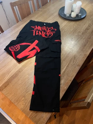 Minus 2 cargos  - Tjena säljer mina minus two convertible-black-graff-cargos-red-logo Har köpt dessa byxor för ungefär 2 månader sen säljer byxor för har inte använt dom så mycket så de är i bra skick och de går även att göra dom till shorts 