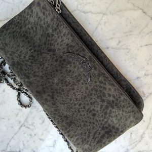 Zadig & Voltaire väska grå svagt mönstrad mocka - Nu säljer jag min jättesnygga Zadig väska när den tyvär inte kommer till användning längre.💗Jag har använt den varsamt så den är i väldigt bra skick🥂🪩Väskan säljs inte längre så den är speciell✨Nypris: ca 4400kr⭐️🌟Säljer för 1600 priset kan diskuteras