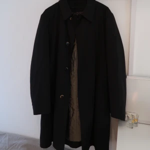 Svart Bugatti kappa  - Helt oanvänd kappa! Väldigt fin till hösten! Kappan är ca 100cm lång och är fodrad:) (köpt för ca 4000kr) 