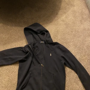 POLO zip up  - Skön och snygg POLO Ralph lauren zip up. Völdigt bra skick 7/10. Säljer denna då den är för liten. Ny pris är ungefär 1700-2000. Säljer för 1100kr