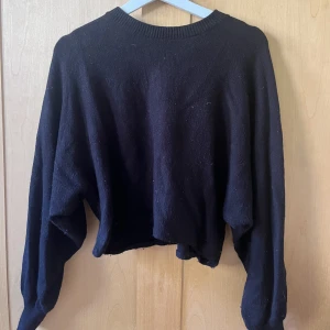 Svart croppad tröja - Säljer min croppade svarta tröja med ballongärm från NA-KD. Använd några gånger.