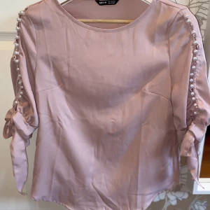 Ljusrosa blus  - Jätte söt ljusrosa blus som är helt oanvänd🌸 Den har små jätte gulliga pärlor vid armarna och en fin rosett på vardera arm🎀 
