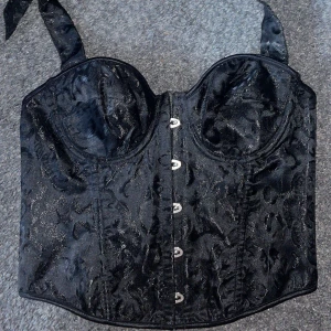 Korsett - Säljer denna skit snygga korsett topp då den aldrig kommit till användning, aldrig använd! Finns snörning i ryggen, snörning från brösten bak i nacken. Vaddering vid brösten finns även. Den är i XL men passar mer M/L!