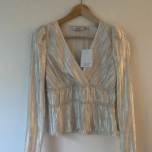 Blus från & Other Stories  - Vacker blus från & Other Stories. Prislappen är kvar. Har aldrig använt den. Vit nästan benvit färg och glansigt material. Nypris 790kr.  