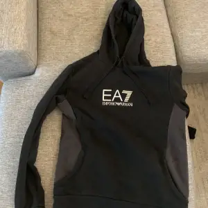 EA7 hoodie i bra skick ser väldigt fräsch ut. Storlek M. Hel svart förutom under armarna längst sidan av bröstet  där den är grå. 