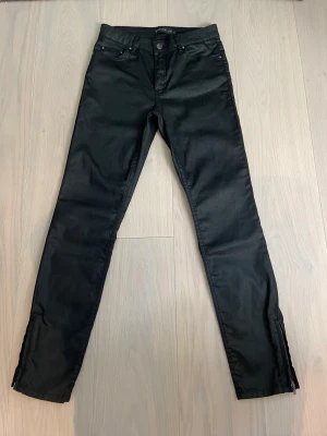 Byxor Stockholm MQ - Svarta snygga Olivia coated trousers ifrån MQ. Använda fåtal gånger, byxorna är i nyskick. Storlek 38, små i storleken och känns mer som 36. Nypris 799 kr.