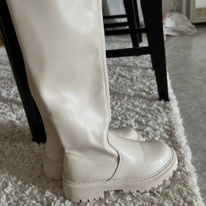 beiga stövlar  - beiga stövlar aldrig använda. går till ca knähöjd 