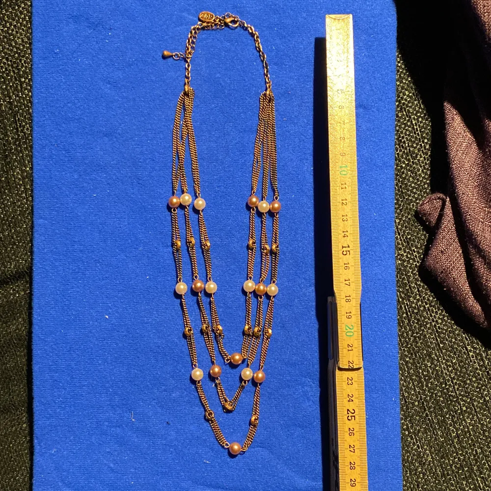 Treradigt halsband med glaspärlor i rosa toner. Asusteet.