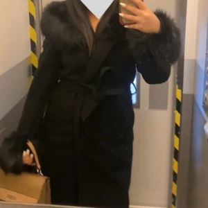 Lång hollies kappa - Använd några få gånger, bra skick. Storlek 38. Den är lång och har inte äkta päls. Håller dig varm