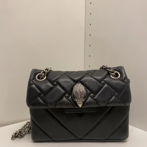 Kurt Geiger väska  - Jag säljer min svarta Kurt Geiger väska i den lilla modellen då den inte kommer till användning längre. Den är hyfsat ny, med lite defekter på undersidan. Skriv för fler frågor eller bilder!💞☺️