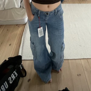 Lågmidjade jeans - Ascoola lågmidjade jeans från Urban Outfitters. De är vida hela vägen med många stora fickor. Älskar dem, men är inte riktigt min stil längre. Använda typ 3 gånger. Säljer endast till bra pris!