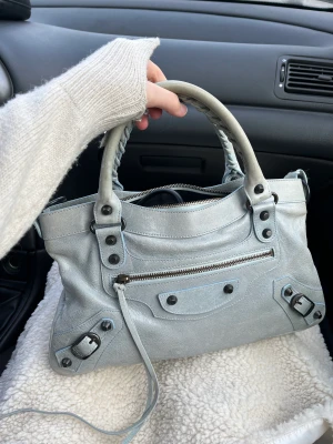 Balenciaga city bag - Intressekoll på min superfina balenciaga city bag !!🩷 köpt på The Vintage Bar på NK för 6750kr men säljer för 6000, pris kan diskuteras ☺️ väskan är i bra skick, dock är handtagen något missfärgade (bild 1)!☺️ äkthetsbevis och spegel finns och följer med !🩵