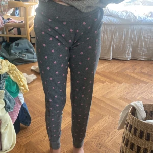 Stjärniga pyjamasbyxor  - Ett par fina gråa pyjamasbyxor med rosa stjärnor på. Vill inte ha dem längre och aldrig använt dem.