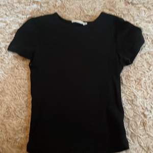 Säljer en svart basic ribbad t-shirt från kappahl i storlek 158/164. Har en sjukt snygg passform. Passar perfekt till sommaren.