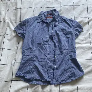 Säljer en blå-vit rutig, kortärmad skjorta i storlek M.
