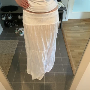 Lågmidjad kjol vit - Ny, oanvänd vit lågmidjad långkjol, köpt i Grekland, säljer då jag har 2, väldigt stretchig och går att vika ner i midjan så passar xxs-m (är s)