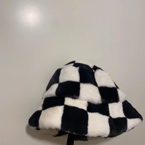 Rutig buckethat - Buckethat i pälsimitation Använd en gång 