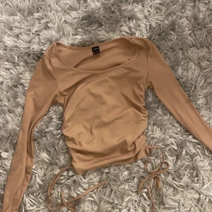 Tröja  - Den har snören på sidan så du kan välja hur lång den ska vara. 