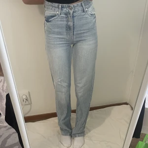 Jeans - Säljer ett par blåa högmidjade jeans i storlek 32. Jeansen är som nya och är gjorda i ett väldigt skönt material. 