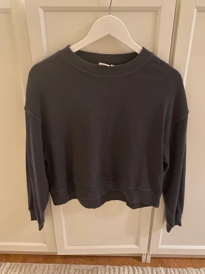 Croppad tröja - Grå croppad långärmad i frottématerial, i använt skick. Kan finnas lite noppror, därav priset.
