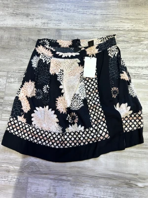 Kjol - Kjol från h&M aldrig använd. Kjolen är i beige svart färger och med blommig design.