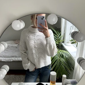 Stickad tröja - Vit stickad tröja med håliga detaljer på framsidan. Tröjan har en liten krage och lite vidare armar. Storlek S ifrån Gina tricot. Tröjan är i bra skick.