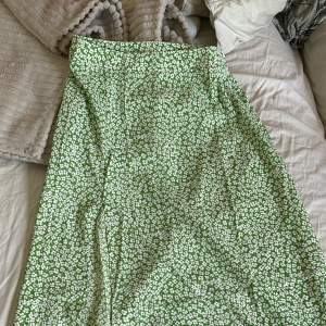 Grön kjol med slits! Superfin färg och har ett mönster med vita blommor på!💚