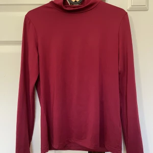 Röd turtleneck - Mörkröd turtleneck, lite mörkare än vad det ser ut på bilden. Ganska glansigt material, tajt modell.