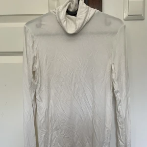 Vit turtleneck - Lång vit turtleneck som är i jättemjukt material (: använder bara svarta turtlenecks så säljer denna!! Ganska genomskinlig som det syns i bilden, men har nude under så löser det sig!